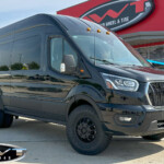 Black Ford Transit 350HD with 2" Transit Off Road Lift on 16" Method Race MR901 Wheels in Matte Black & 235/85R16 Toyo Open Country A/T III Tires Black Ford Transit 350HD with 2" Transit Off Road Lift on 16" Method Race MR901 Wheels in Matte Black & 235/85R16 Toyo Open Country A/T III Tires