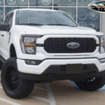 White 2023 Ford F150 FX4 with 6" Rough Country Lift on 20" TIS 544GB Wheels & 35x12.50R20 Nitto Ridge Grappler Tires