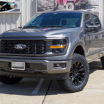 Gray 2024 Ford F150 STX with Rough Country Level on 20x9 Fuel Off-Road D804 Flame Wheels in Blackout & 35x11.50R20 Nitto Recon Grappler Tires