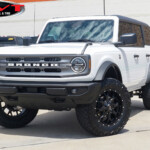 White 2024 Ford Bronco with 2" Rough Country Lift on 20" Mayhem Warrior Wheels in Matte Black & 35x12.50R20 Venom Power Terra Hunter X/T Tires White 2024 Ford Bronco with 2" Rough Country Lift on 20" Mayhem Warrior Wheels in Matte Black & 35x12.50R20 Venom Power Terra Hunter X/T Tires